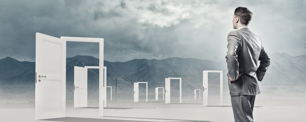 Uomo determinato davanti a molte porte aperte