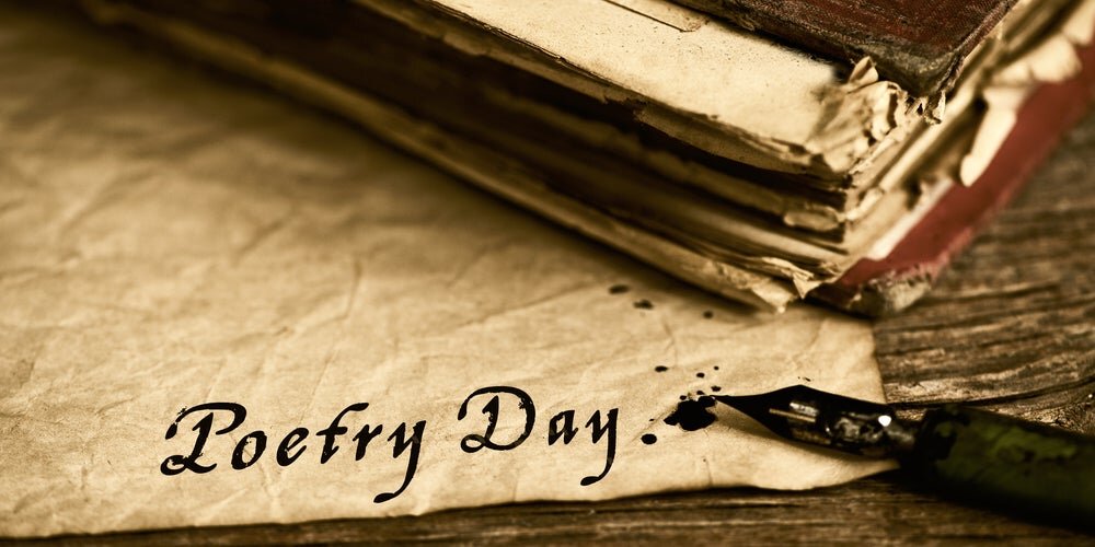 serie di fogli, libro, penna stilografica e scritta "Poetry Day"