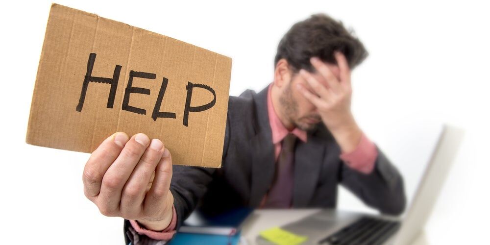 Uomo che chiede aiuto con un cartello per finire il lavoro