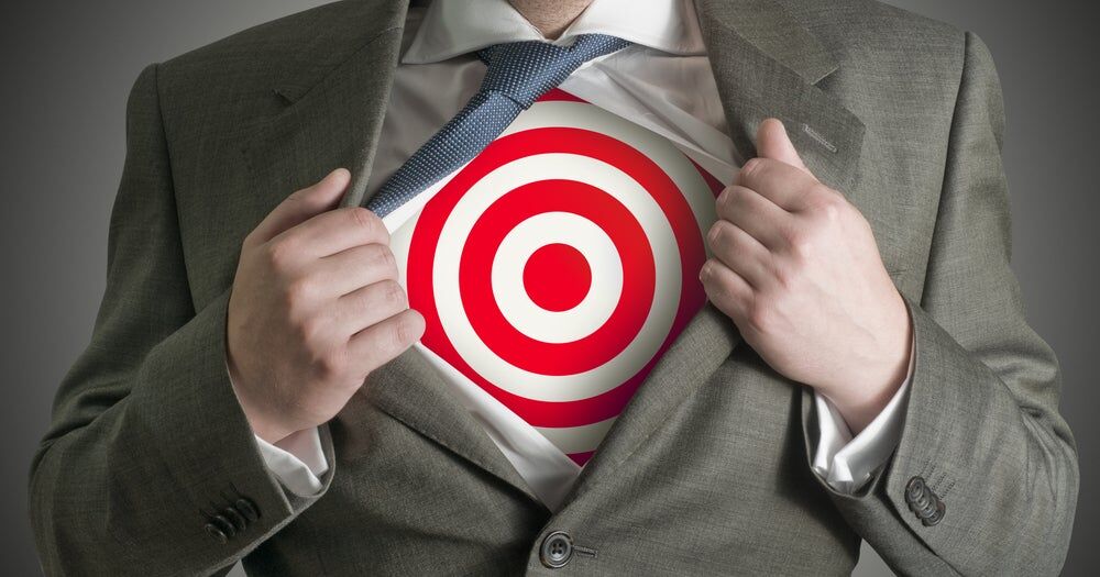 Uomo che sotto la giacca indossa una maglietta con un bersaglio