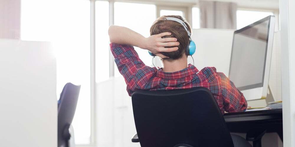 Ragazzo che ascolta la musica seduto alla scrivania con le cuffie