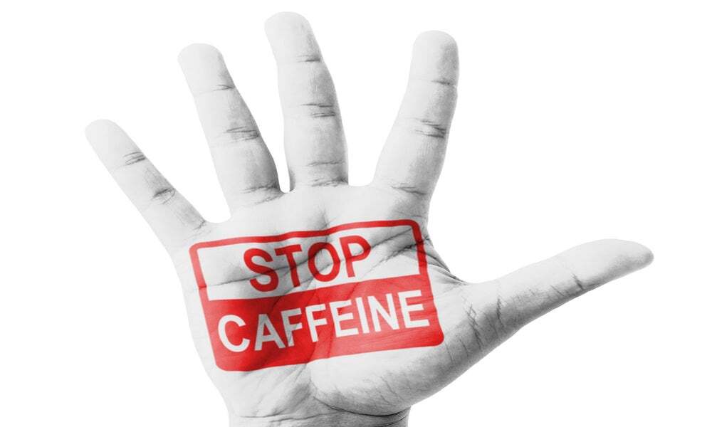 Mano bianca con un segno rosso che dice Stop Caffeine