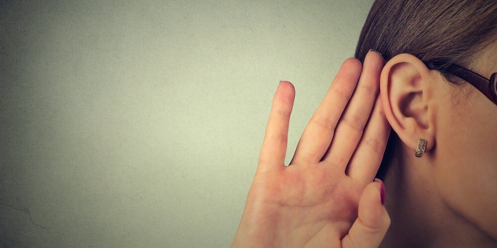 Donna che tende l’orecchio per ascoltare